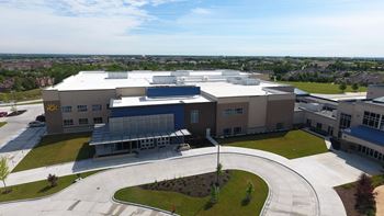 an aerial view of a building with solar panels on the roof